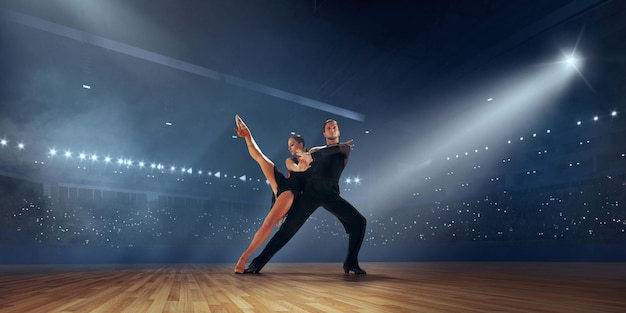 Kostenloses Foto paartänzer führen lateinamerikanischen tanz auf großer professioneller bühne gesellschaftstanz auf