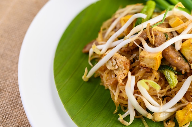 Pad Thai in einem weißen Teller auf einem Holztisch