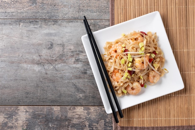 Kostenloses Foto pad thai mit garnelen und gemüse auf holztisch