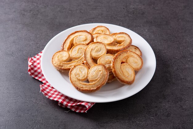 Palmier Blätterteig in der Platte auf schwarzem Schieferhintergrund