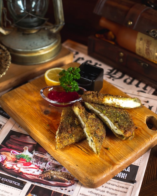 Paniertes Fleisch serviert mit Sauce, Zitrone und Gemüse