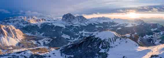 Kostenloses Foto panoramaaufnahme der berge, die im schnee bei sonnenuntergang bedeckt sind