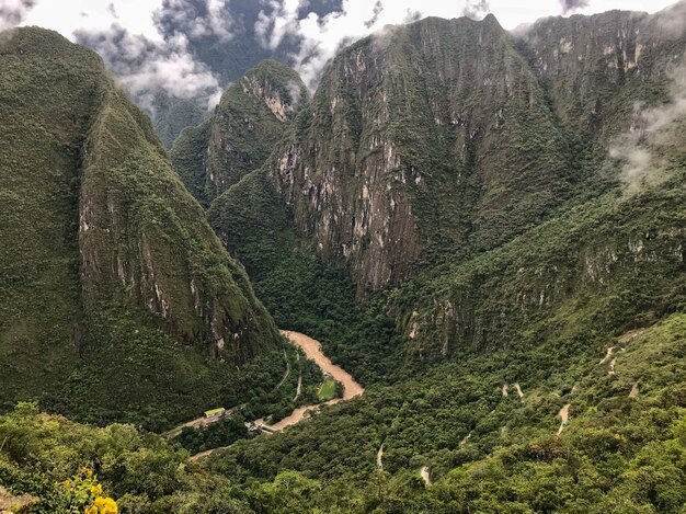 Panoramaaufnahme eines braunen Flusses inmitten der grünen Berge des majestätischen Machu Picchu