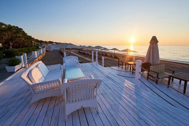 Panoramablick auf den Sandstrand am Strand mit Sonnenliegen und Sonnenschirmen gegen Meer und Berge. Hotel. Resort. Tekirova-Kemer. Truthahn