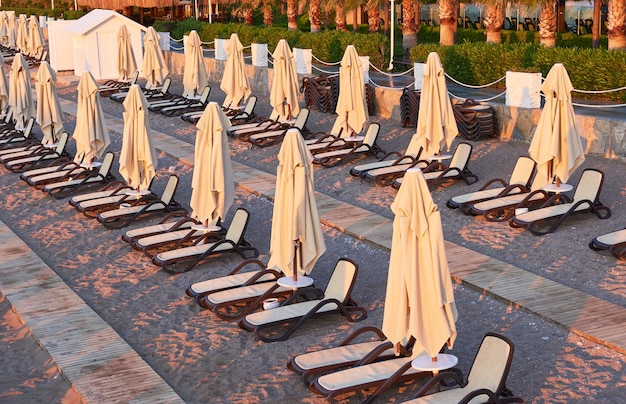 Panoramablick auf privaten Sandstrand mit Sonnenliegen und Parasokamy das Meer und die Berge. Resort.