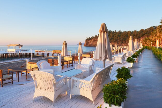 Panoramablick auf privaten Sandstrand mit Sonnenliegen und Parasokamy das Meer und die Berge. Resort.