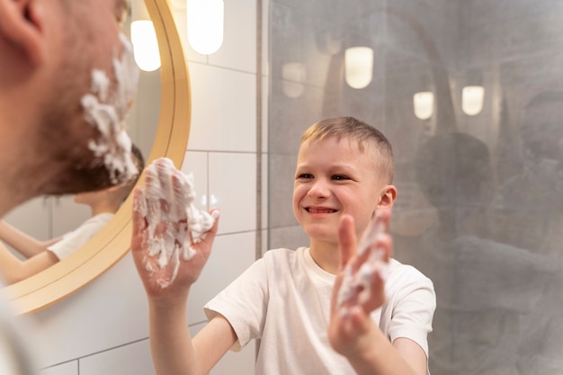 Kostenloses Foto papa bringt seinem sohn das rasieren bei