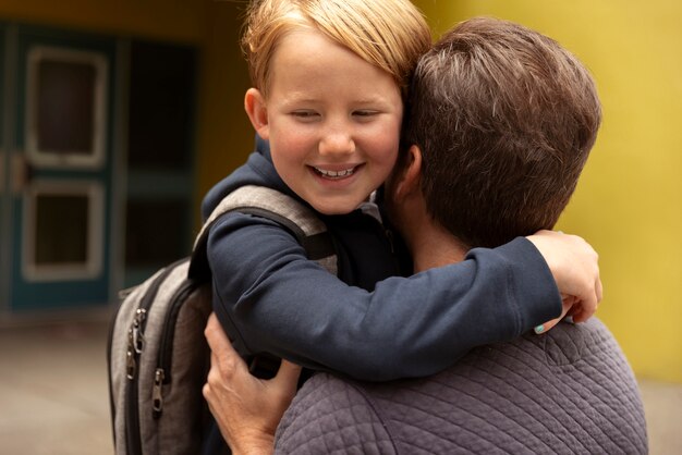 Papa geht mit seinem Kind am ersten Schultag spazieren