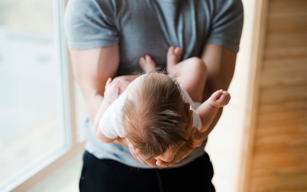 Papa hält Baby auf Händen