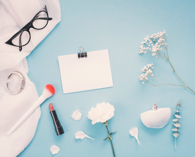 Papier mit Blumen und Kosmetik auf dem Tisch