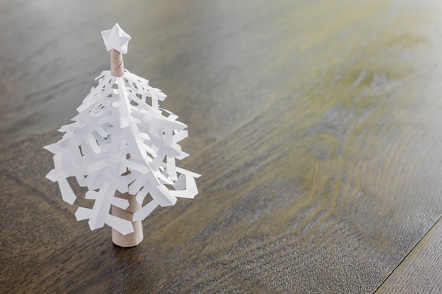 Kostenloses Foto papier schneeflocken weihnachtsbaum auf holztisch