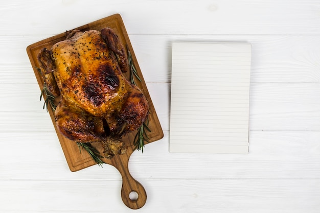 Kostenloses Foto papierblatt nahe gebratenem huhn