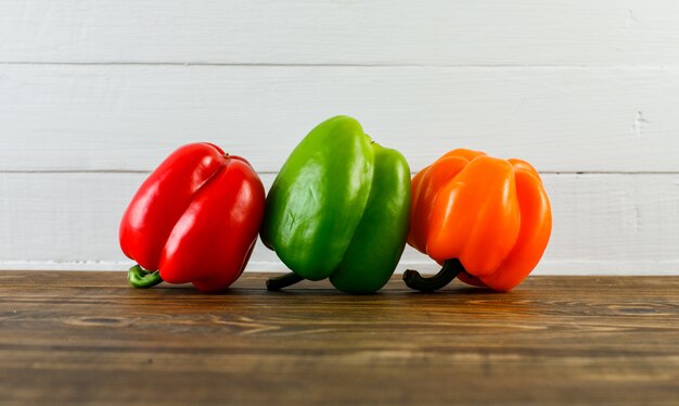 Paprika auf dunkler und weißer Holzoberfläche, Seitenansicht.