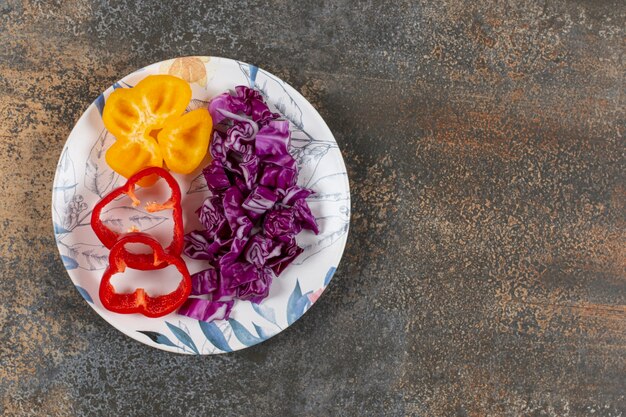 Paprika und fein gehackter Rotkohl auf der Marmoroberfläche