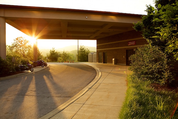 Parkplatz umgeben von Grün und Motorrädern während des Sonnenuntergangs