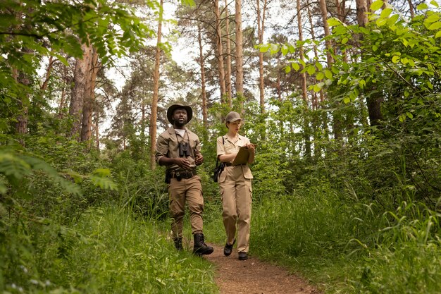 Parkwächter mit vollem Schuss, die im Wald spazieren gehen