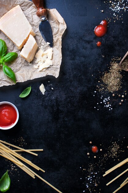 Parmesan Pasta-Rezept mit einem Stück Käse und rohen Nudeln und anderen Zutaten