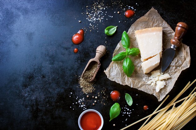 Parmesan Pasta-Rezept mit einem Stück Käse und rohen Nudeln und anderen Zutaten