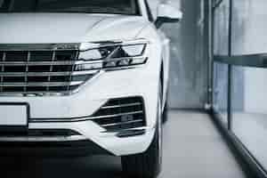 Kostenloses Foto partikelansicht des modernen weißen luxusautos, das tagsüber drinnen geparkt wird