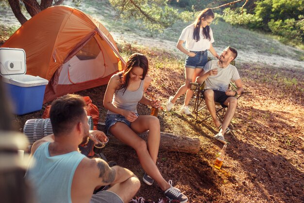Party, Camping der Männer- und Frauengruppe am Wald. Sie entspannen sich