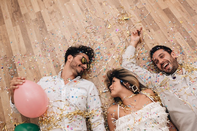 Kostenloses Foto party leute auf dem boden posieren mit konfetti
