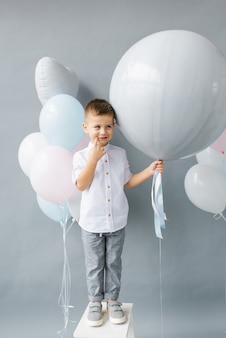 Party zur enthüllung des geschlechts ein vierjähriges kind hält einen ballon in den händen, um das geschlecht herauszufinden
