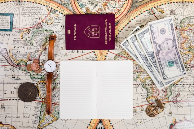 Kostenloses Foto pass, banknoten, armbanduhr, münzen und notizblock auf karte