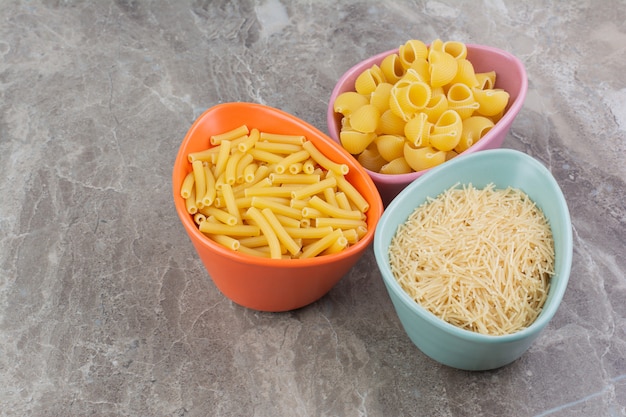 Pasta in einer rosa Schüssel auf dem Marmorraum.