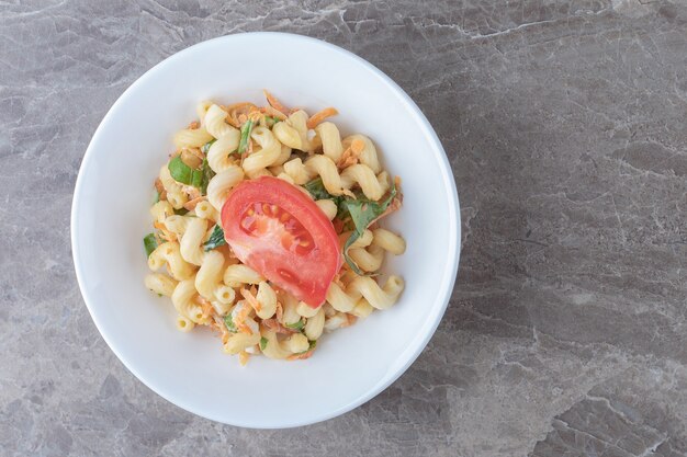 Pasta mit gewürfeltem Gemüse auf weißem Teller.