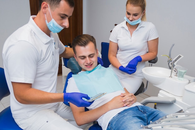 Patient und Zahnarzt, die Zähne betrachten