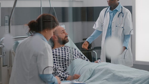Patienten diskutieren mit Ärzten, während sie während der Genesung im Bett liegen