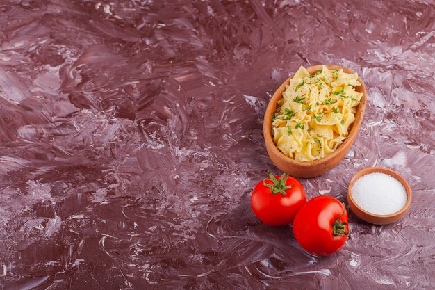 Penne Pasta mit Mayonnaise und frischen roten Tomaten auf einem Leuchttisch.