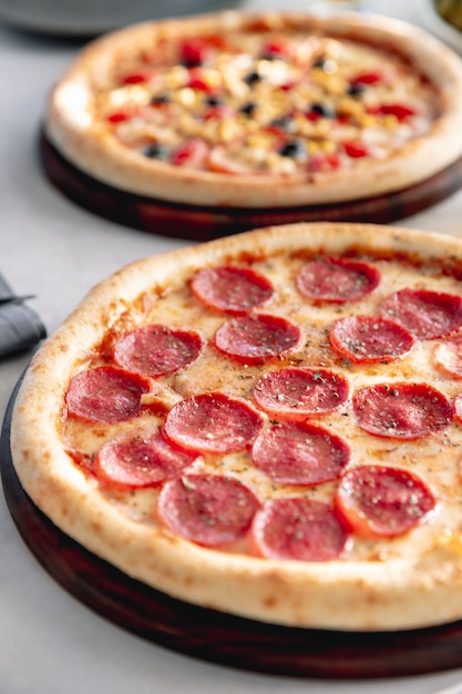 Kostenloses Foto pepperoni-pizza mit kräutern serviert