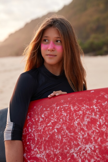 Kostenloses Foto perfekter sonniger tag zum surfen. kontemplativer surfer im neoprenanzug, hat gesunde haut