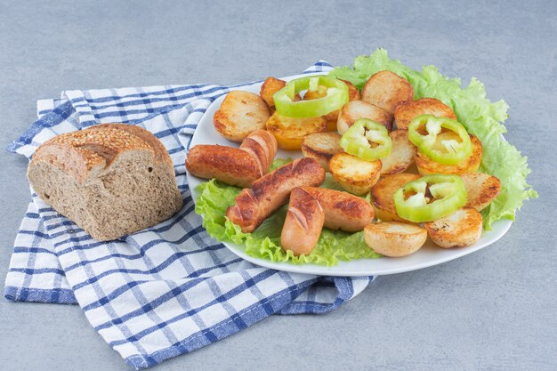 Perfektes Mittagessen. Bratwurst und Kartoffel auf weißem Teller.