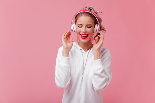 Perky Frau in großen Kopfhörern liebt es, Musik zu hören