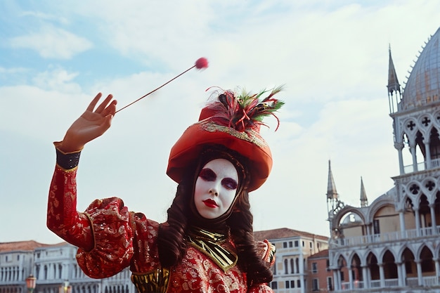 Person, die am Karneval von Venedig mit einem Kostüm und einer Maske teilnimmt