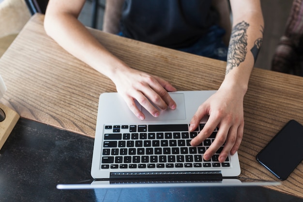 Person, die am Tisch mit Laptop sitzt