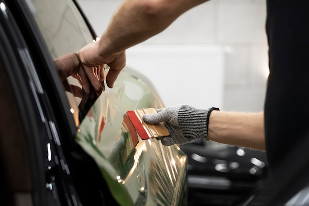 Person, die an der Fahrzeugfolierung arbeitet