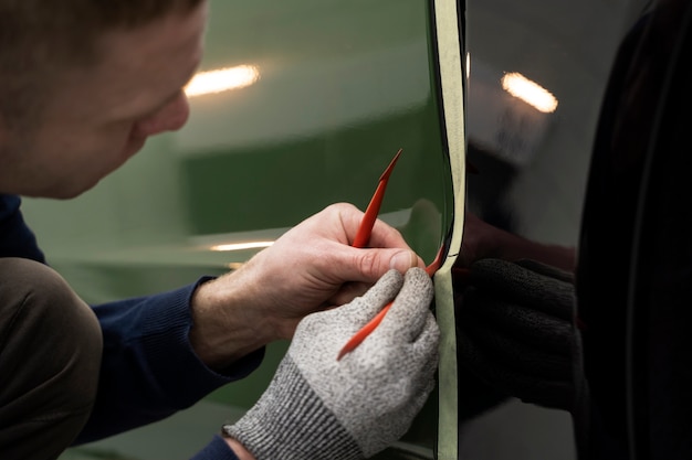 Person, die an der Fahrzeugfolierung arbeitet