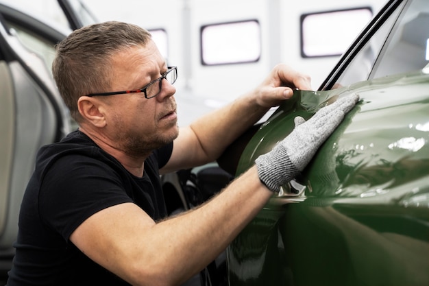 Person, die an der Fahrzeugfolierung arbeitet