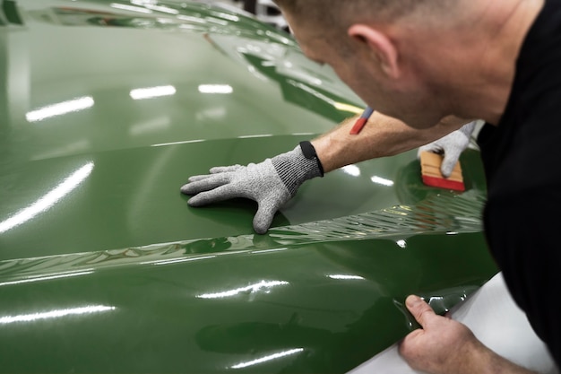 Kostenloses Foto person, die an der fahrzeugfolierung arbeitet