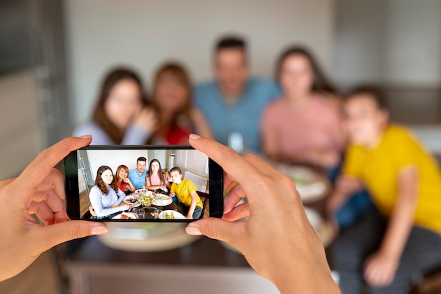 Person, die beim Abendessen ein Foto von der Familie macht