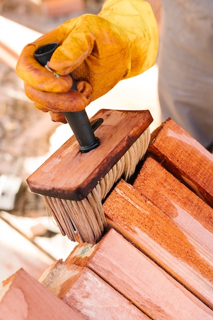 Person, die das Holz lackiert