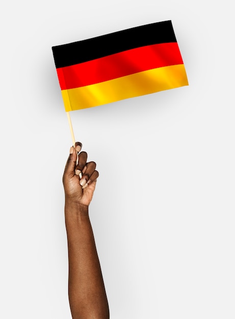 Kostenloses Foto person, die die flagge der bundesrepublik deutschland weht