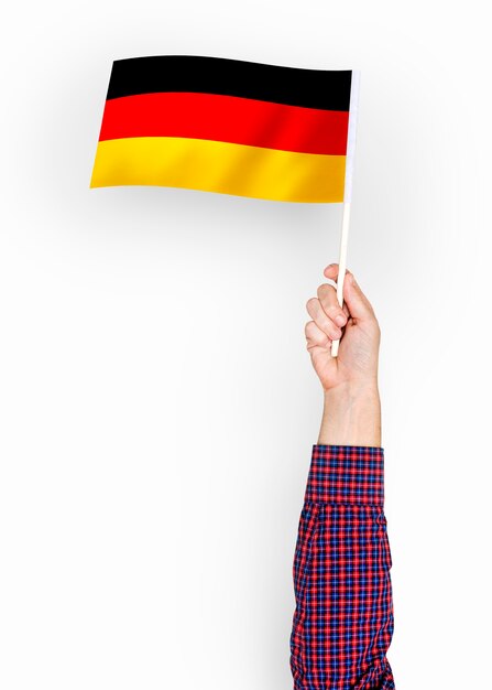 Person, die die Flagge der Bundesrepublik Deutschland weht