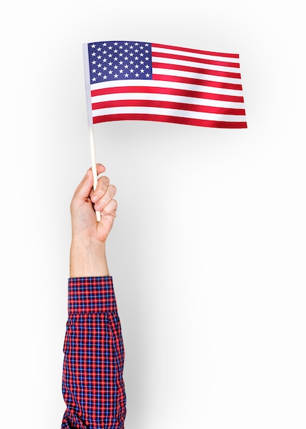 Kostenloses Foto person, die die flagge der vereinigten staaten von amerika wellenartig bewegt