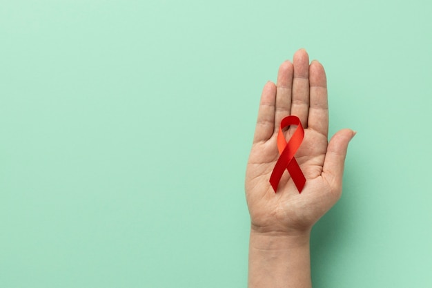 Person, die ein Band zum Welt-Aids-Tag hält