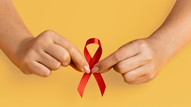 Person, die ein Band zum Welt-Aids-Tag hält