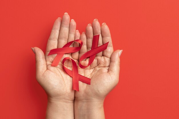 Person, die ein Bandsymbol zum Welt-Aids-Tag hält